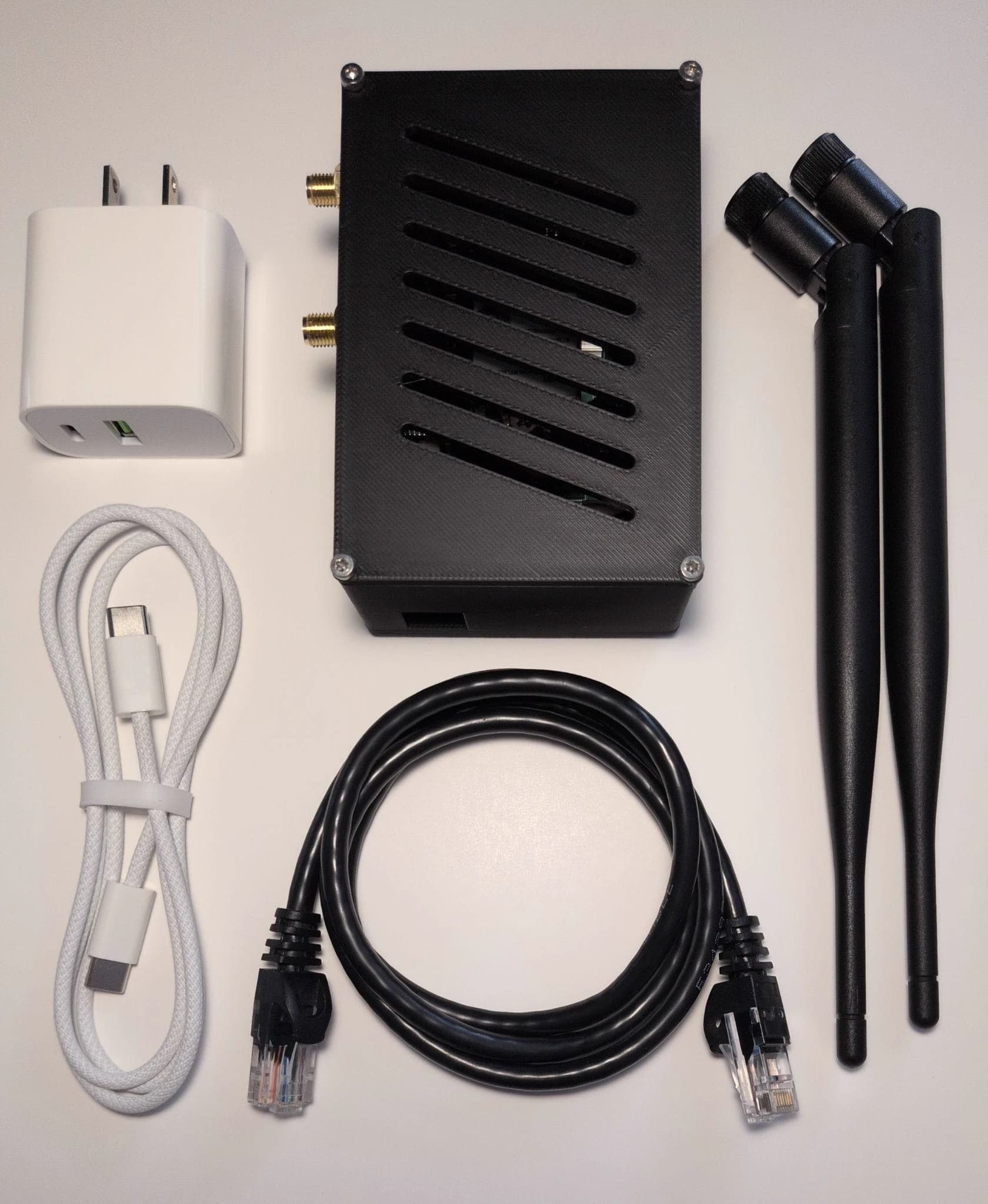 Contents of the Ouzel package include a power cable, power adapter, ethernet cable, antennas, and Ouzel device.